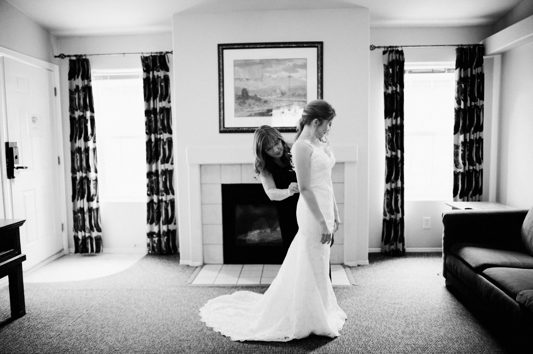 mother helping bride into her dress