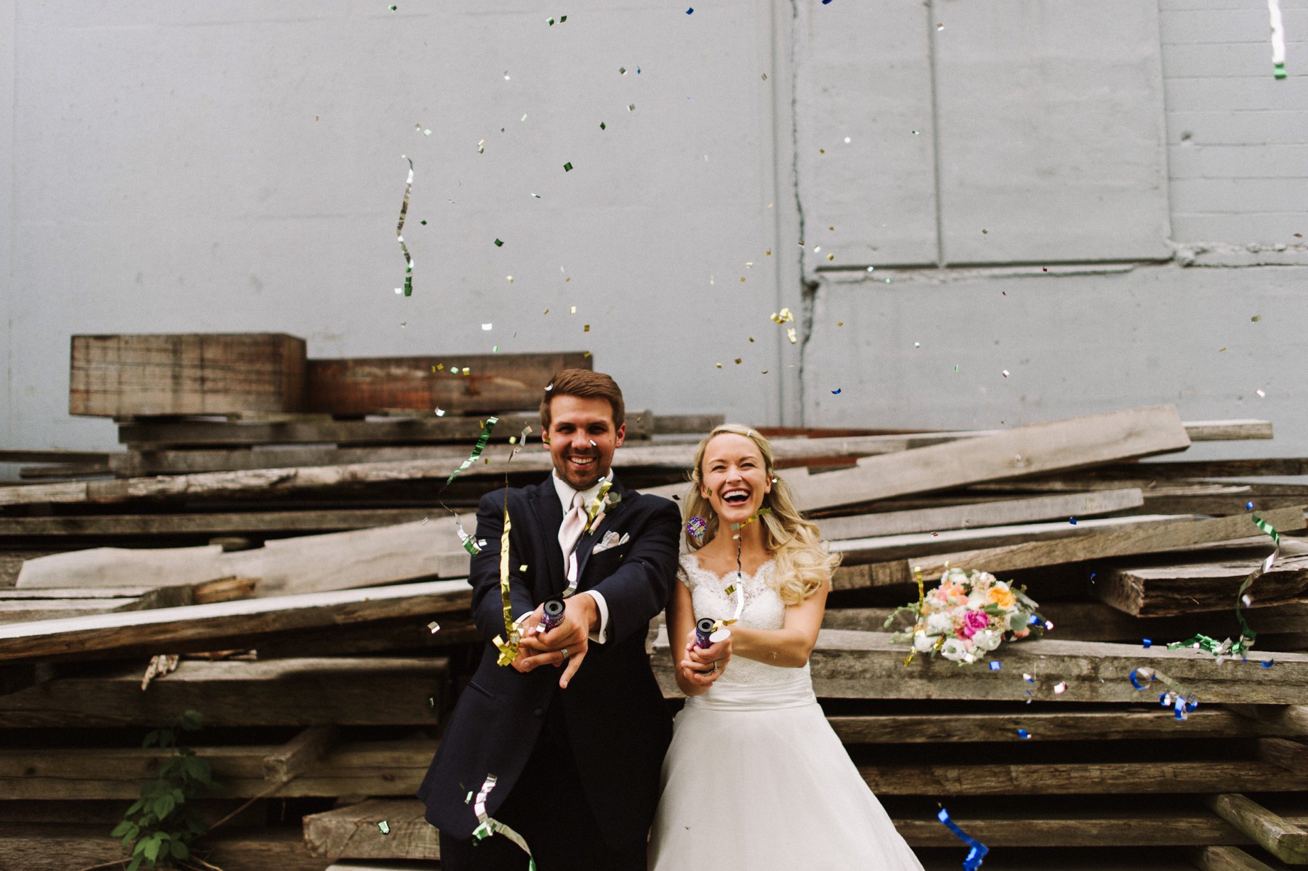 bride and groom with confetti poppers