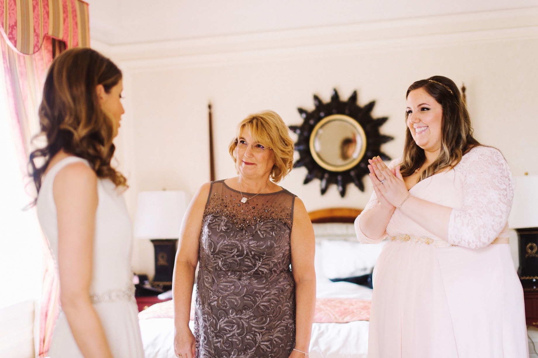 mother and sister seeing bride in dress