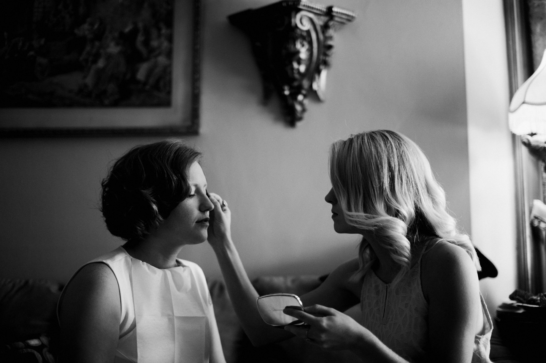 bride putting on makeup before her wedding at the Whitney