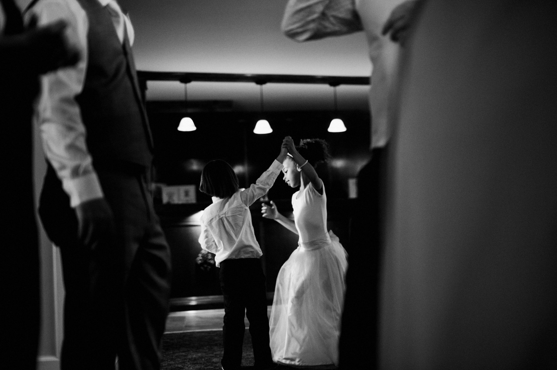 photojournalistic photo of flower girl dancing by michigan wedding photographer heather jowett