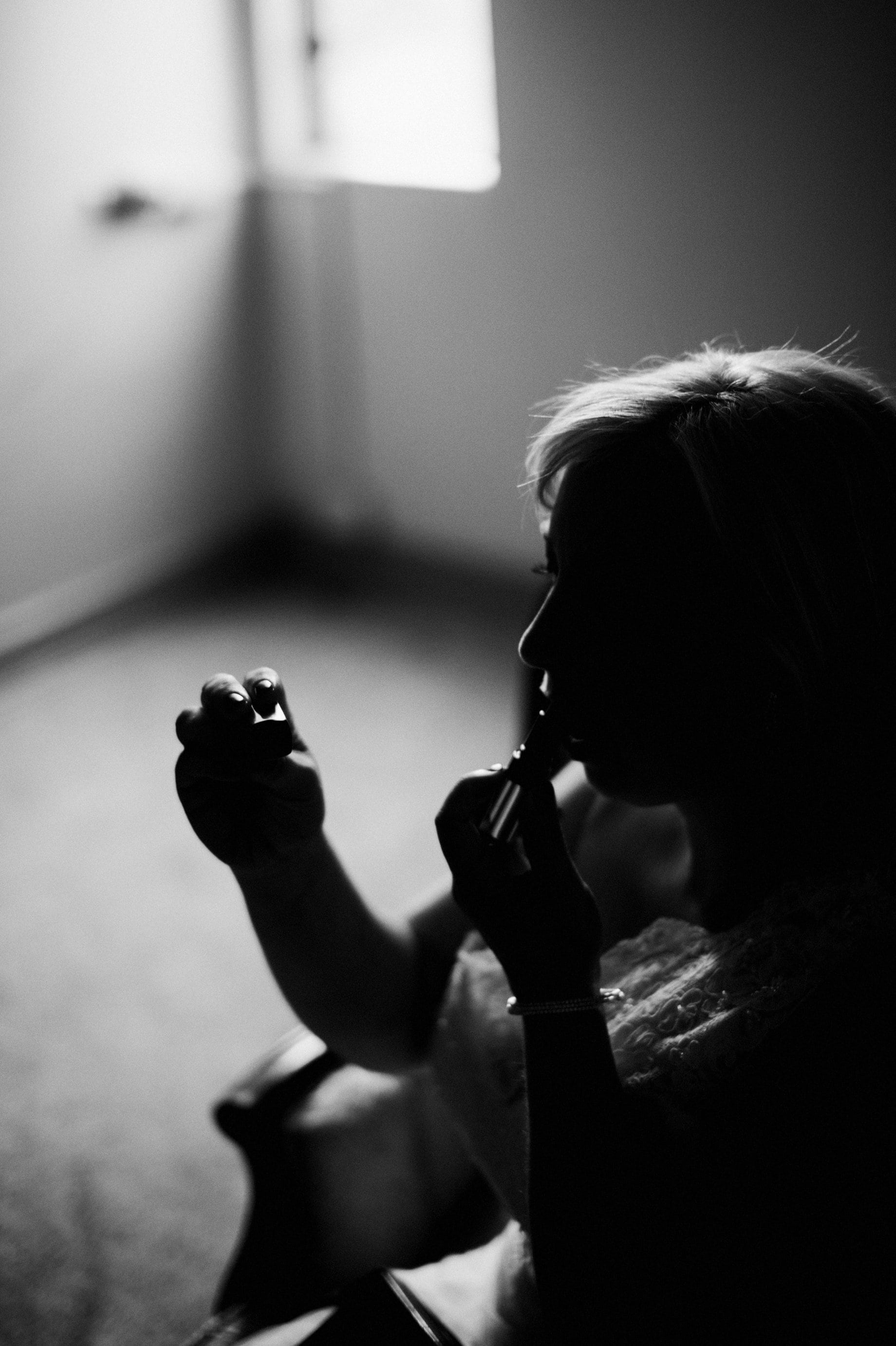 05a dramatic black and white photo of bride putting on lipstick