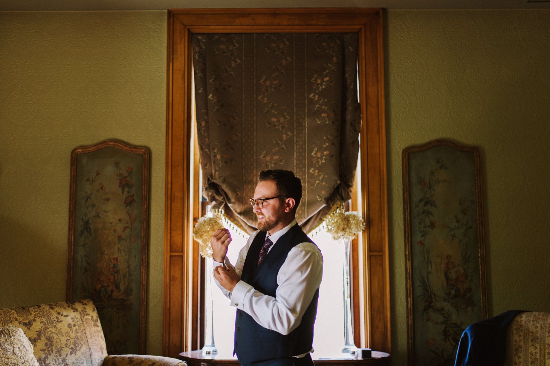 groom putting on cufflinks