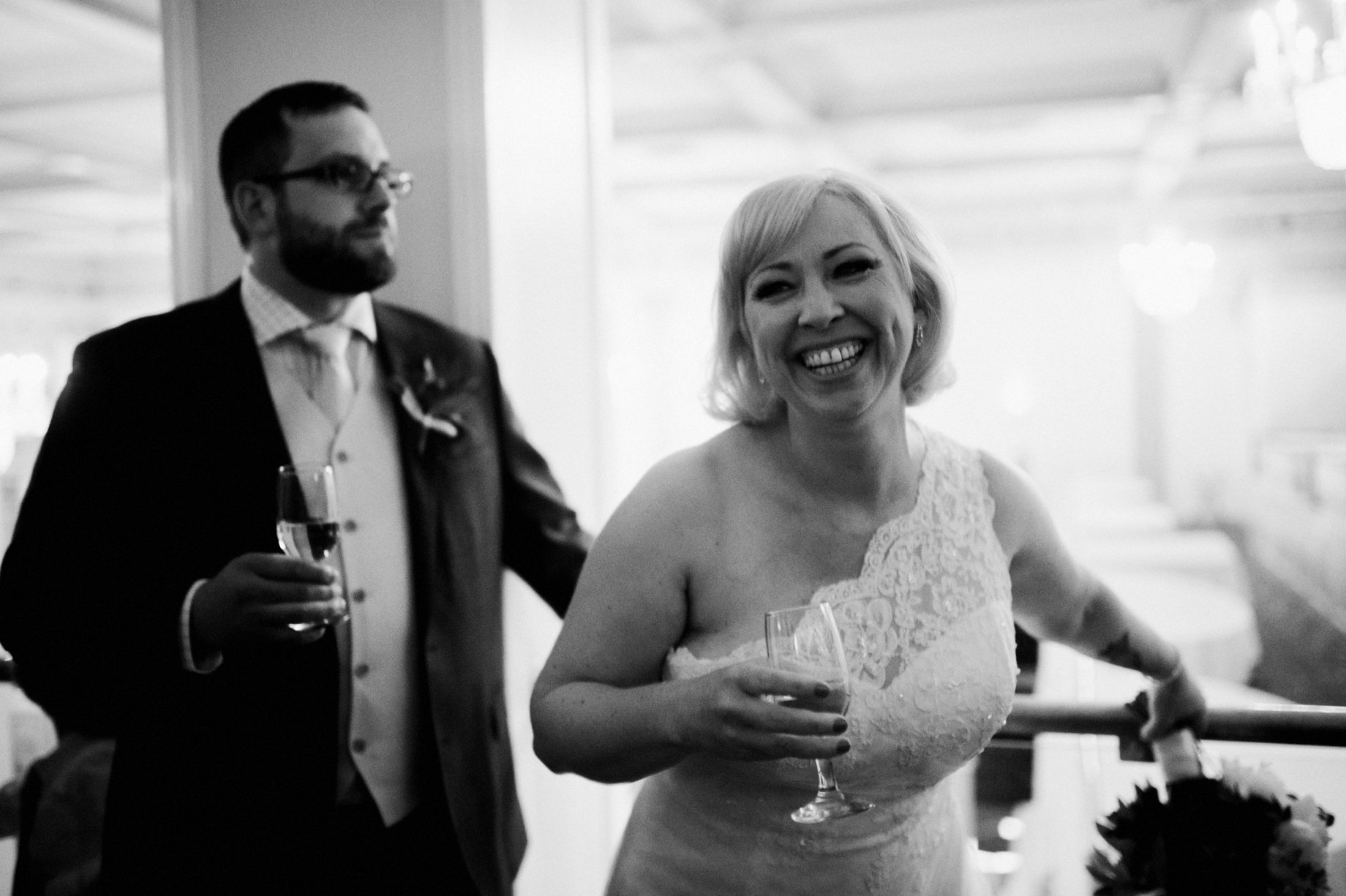 black and white wedding photography of couple toasting