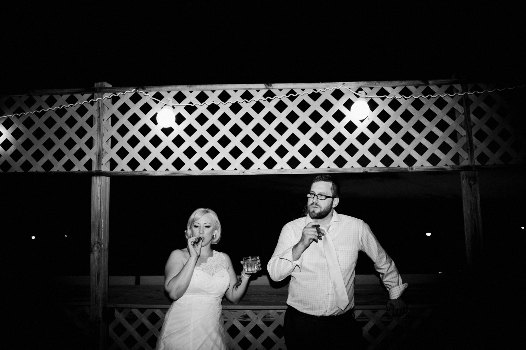 bride and groom share a cigar at their wedding reception by detroit wedding photographer Heather Jowett