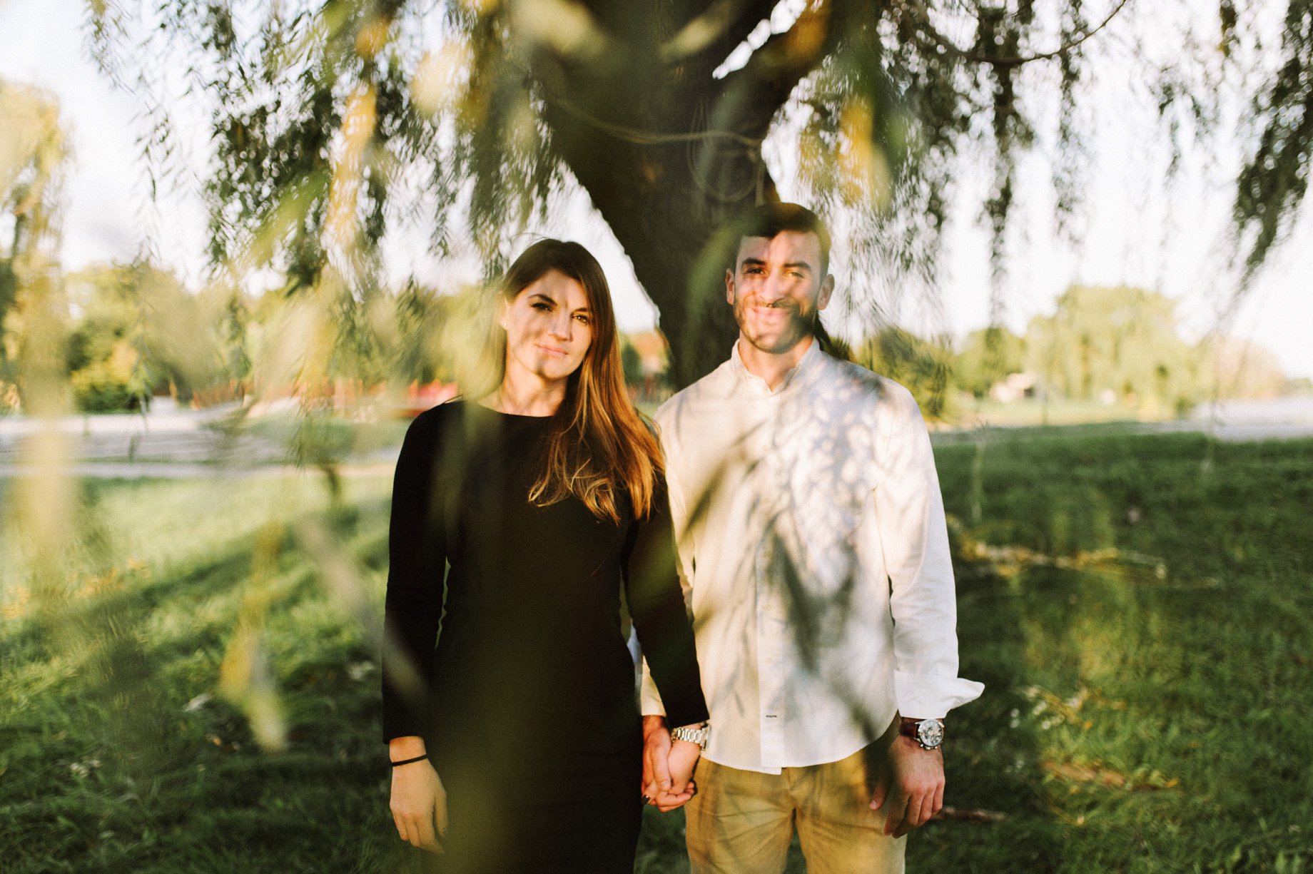 couple posing for engagement photographs in a willow tree