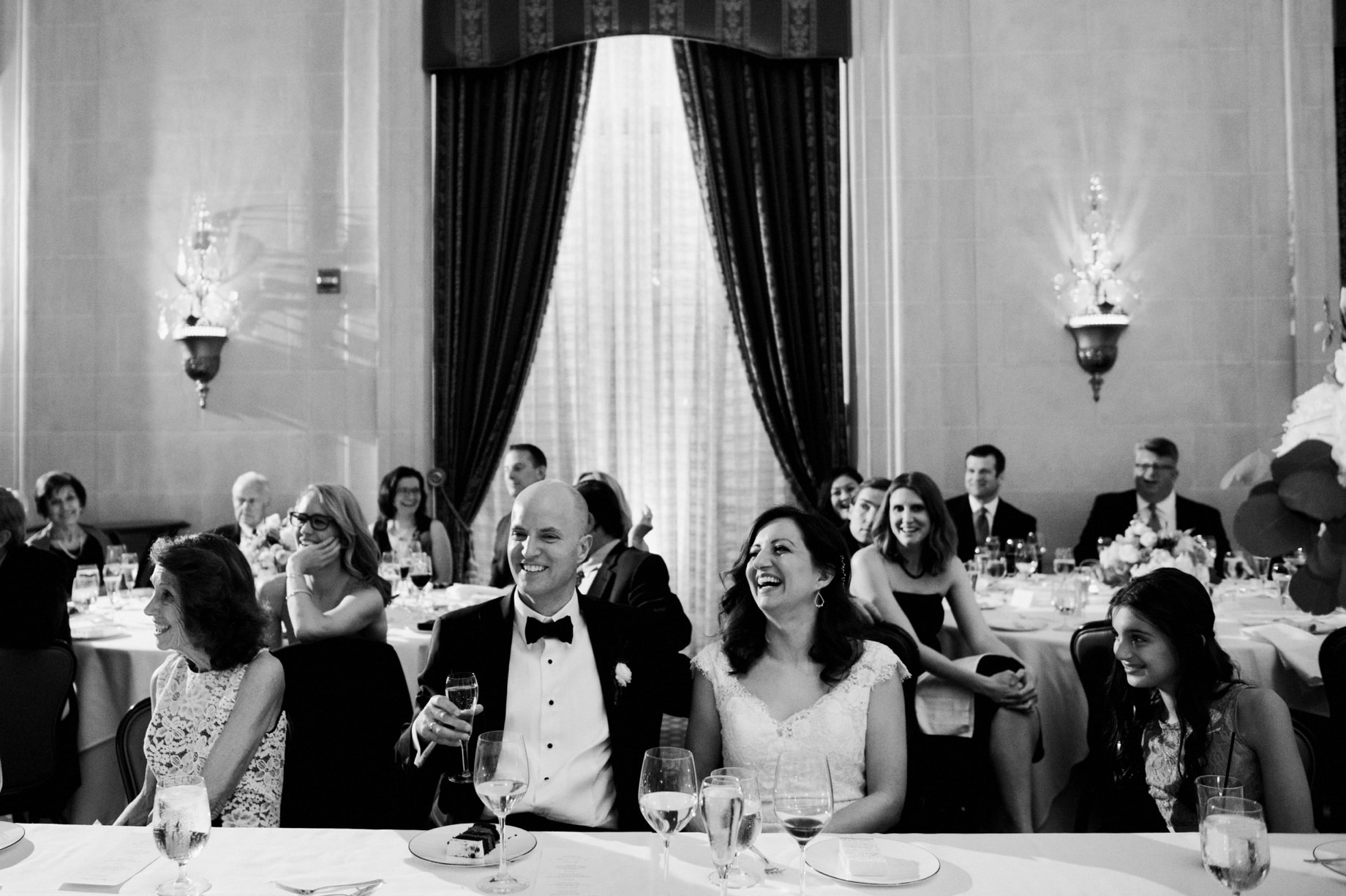 bride and groom laughing at toasts