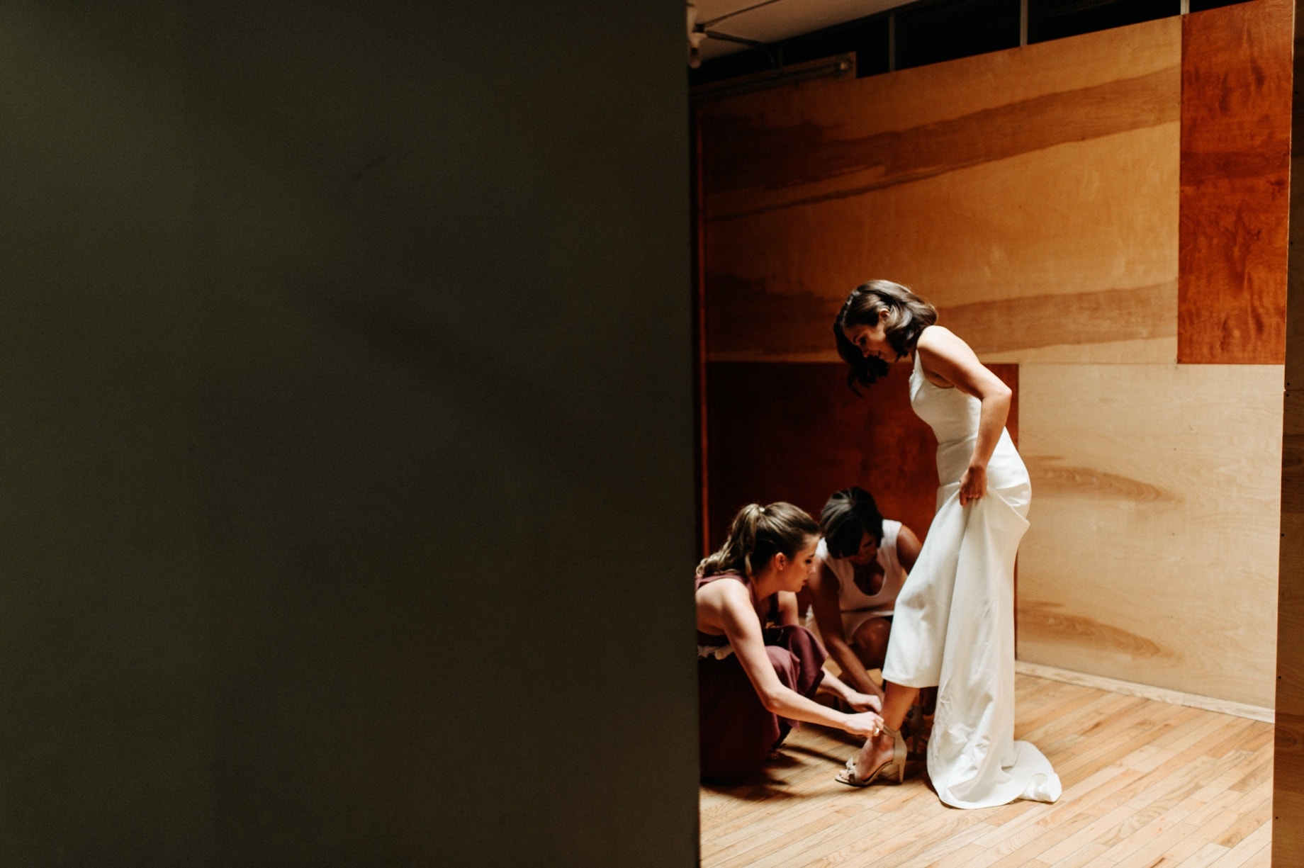 Bride being helped into her shoes