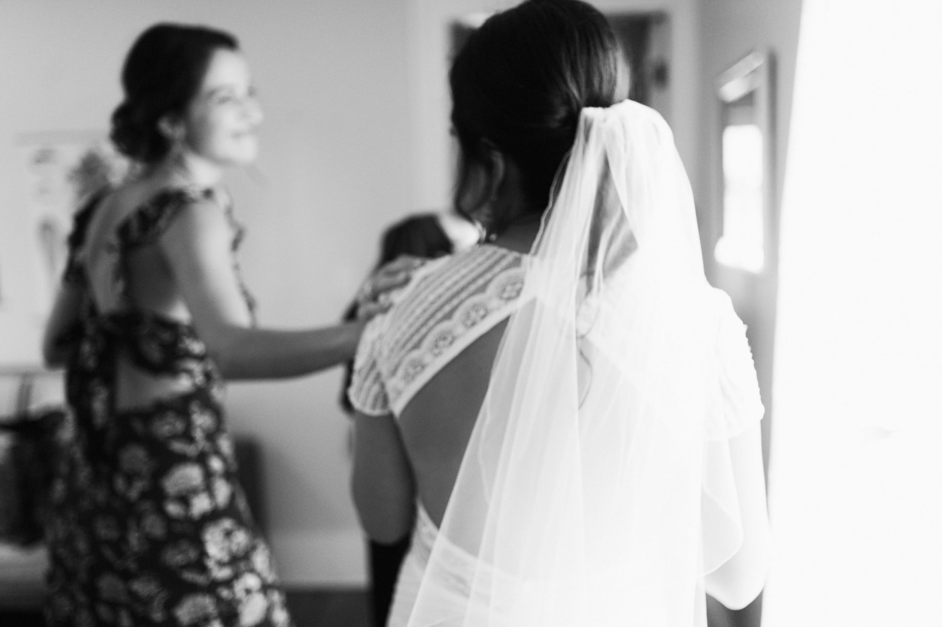 bridesmaid sharing a moment with bride just before ceremony