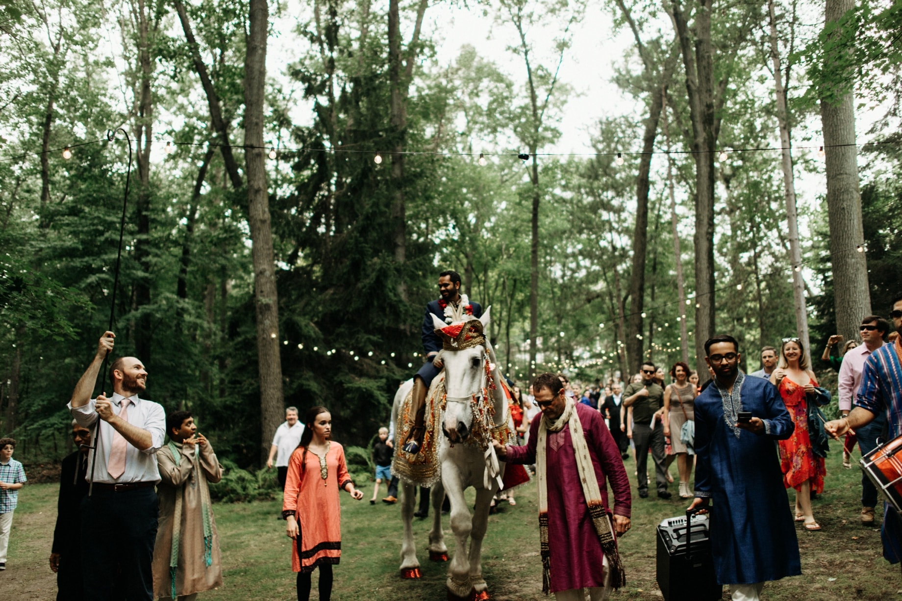 groom entering wedding ceremony on horseback