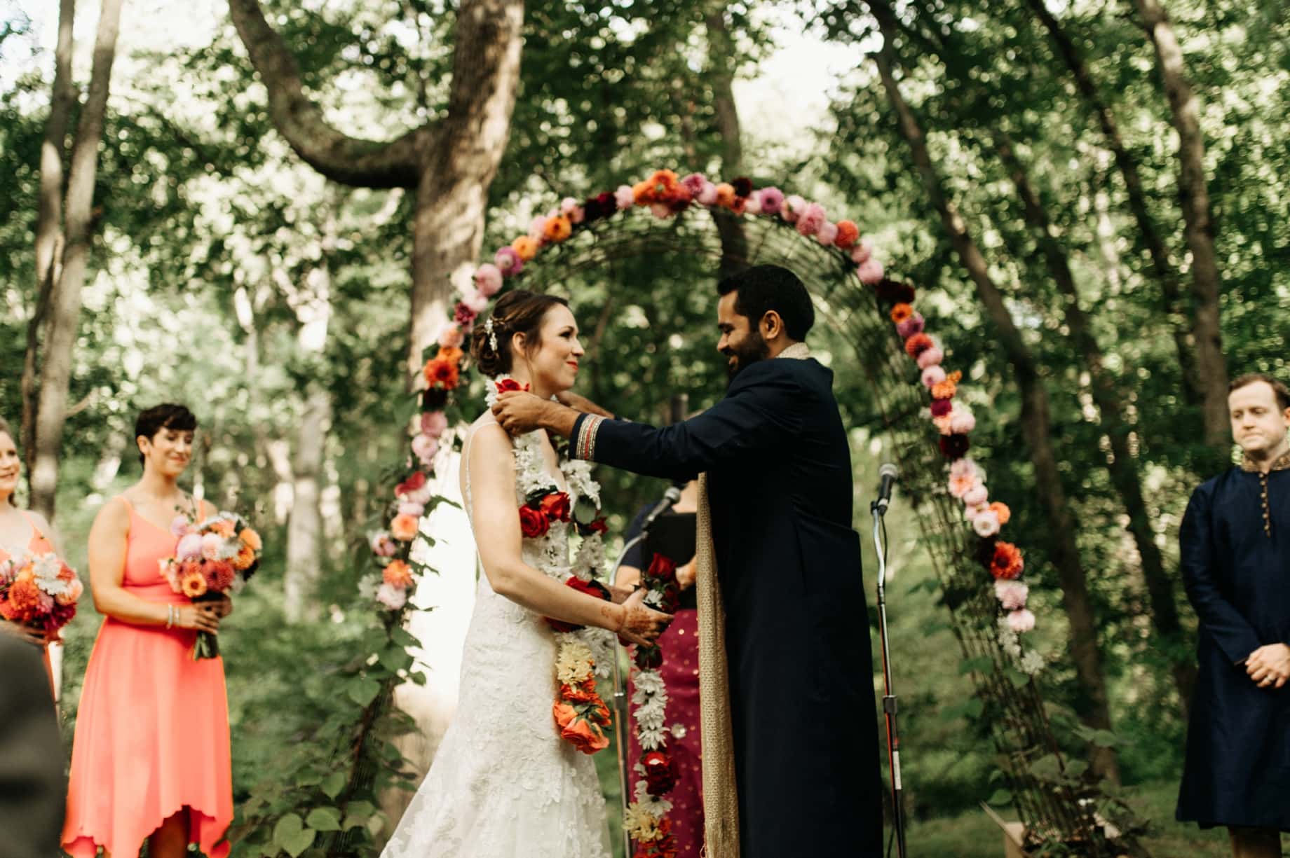 groom places a garland of flowers on his bride during an indian wedding ceremony