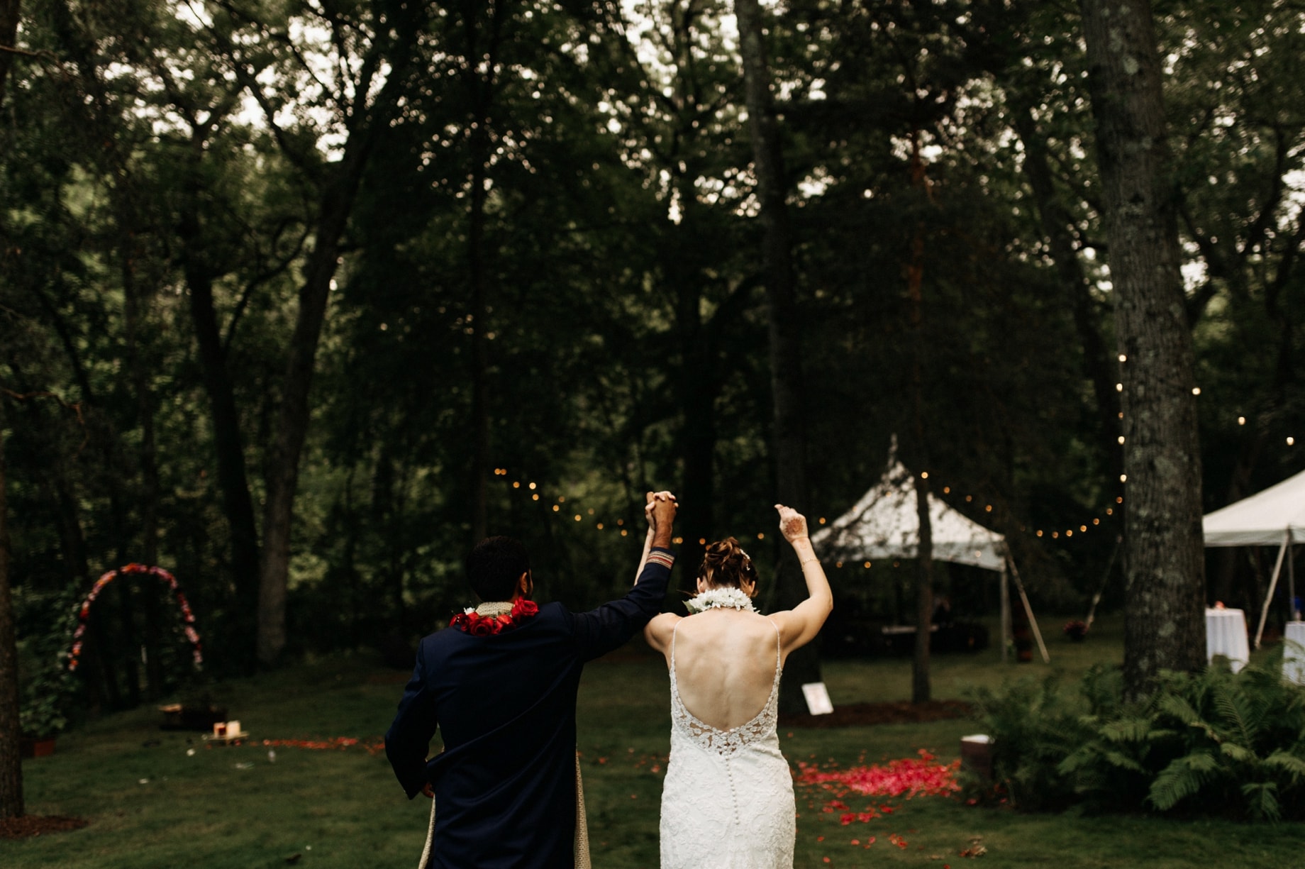 bride and groom entering their backyard wedding reception