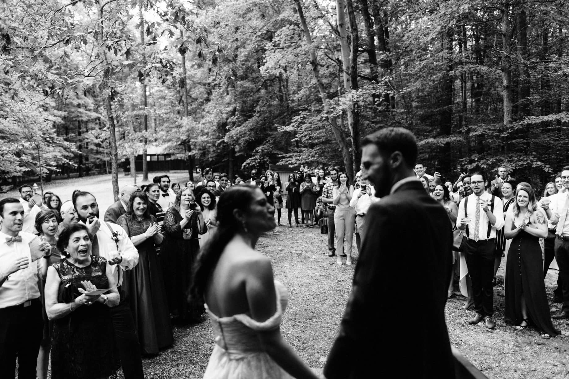 bride and groom are greeted by their guests at the reception