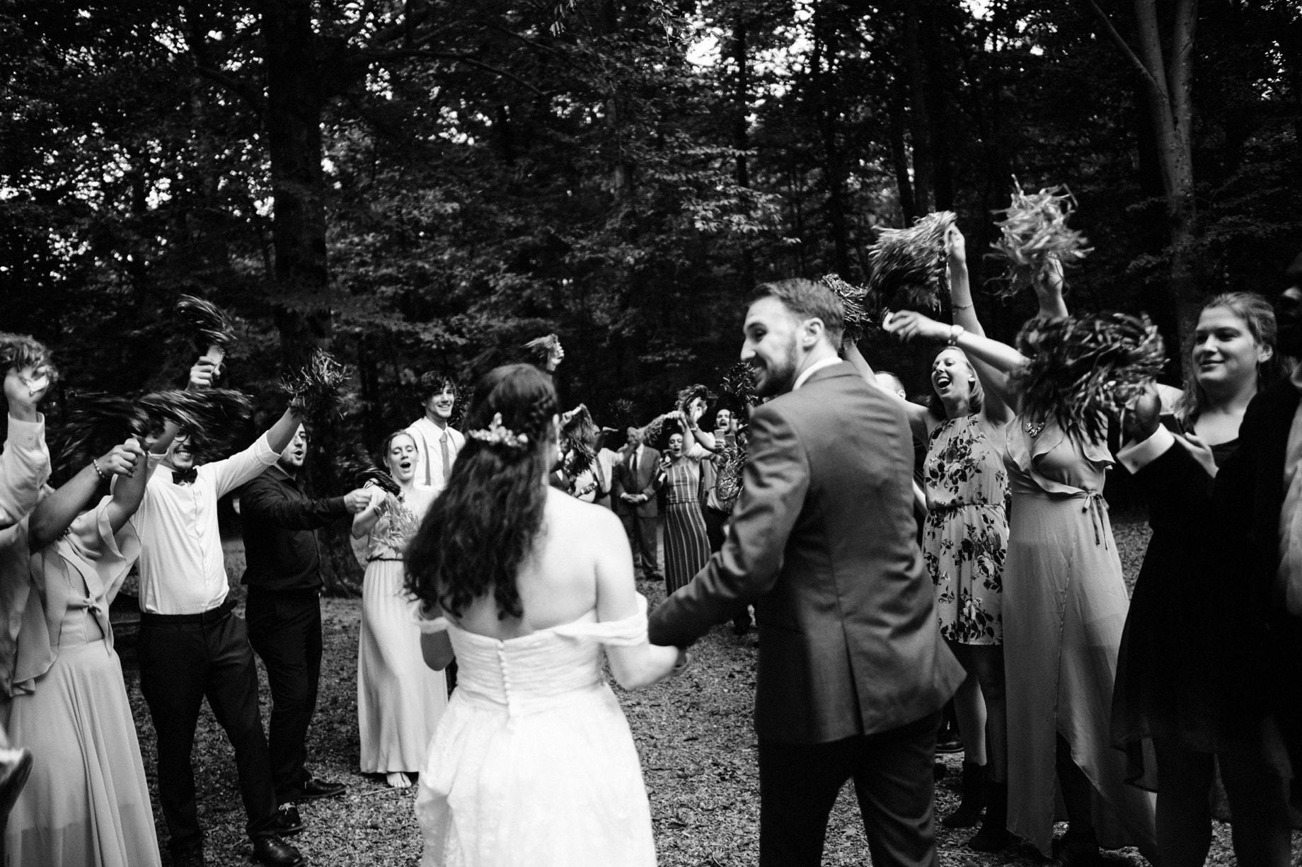 bride and groom exit while guests wave pom poms