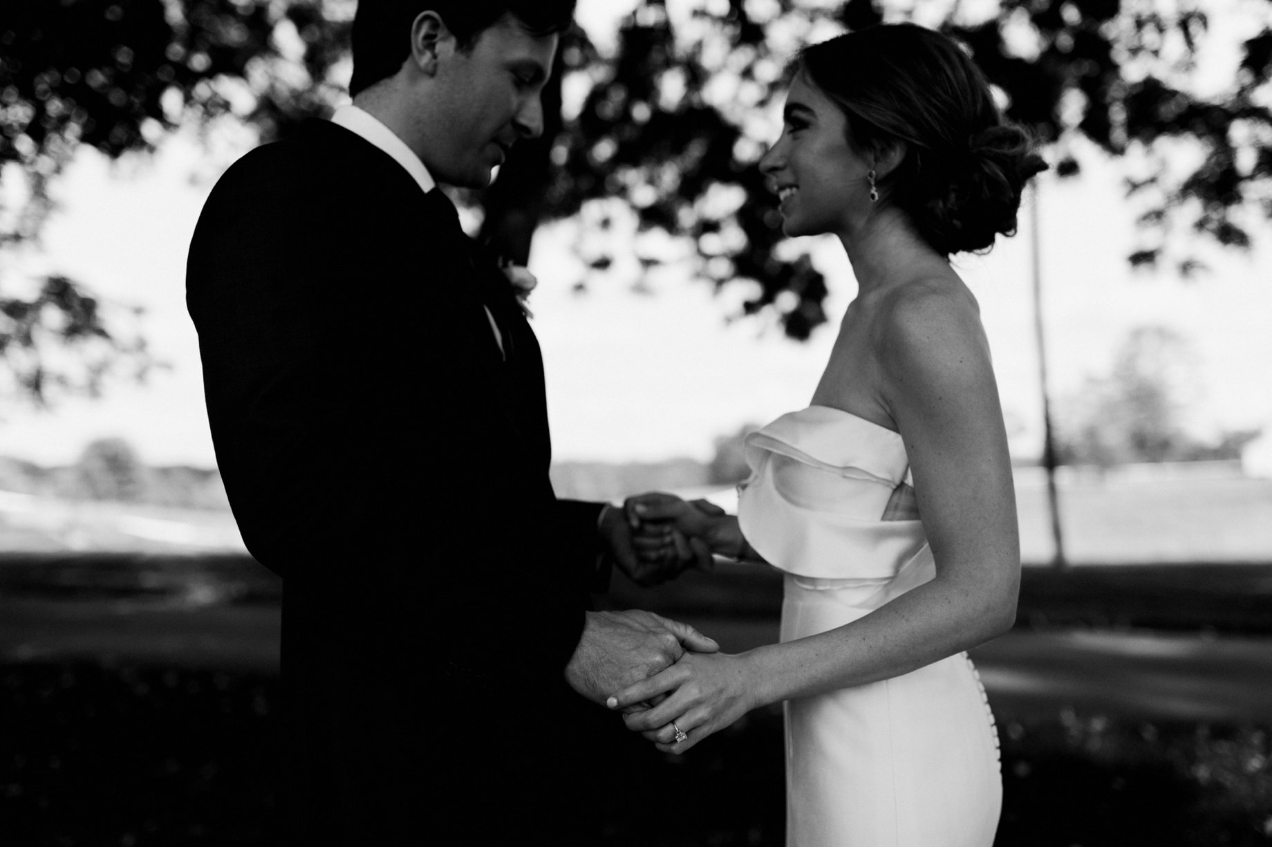 black and white photo of bride and groom holding hands