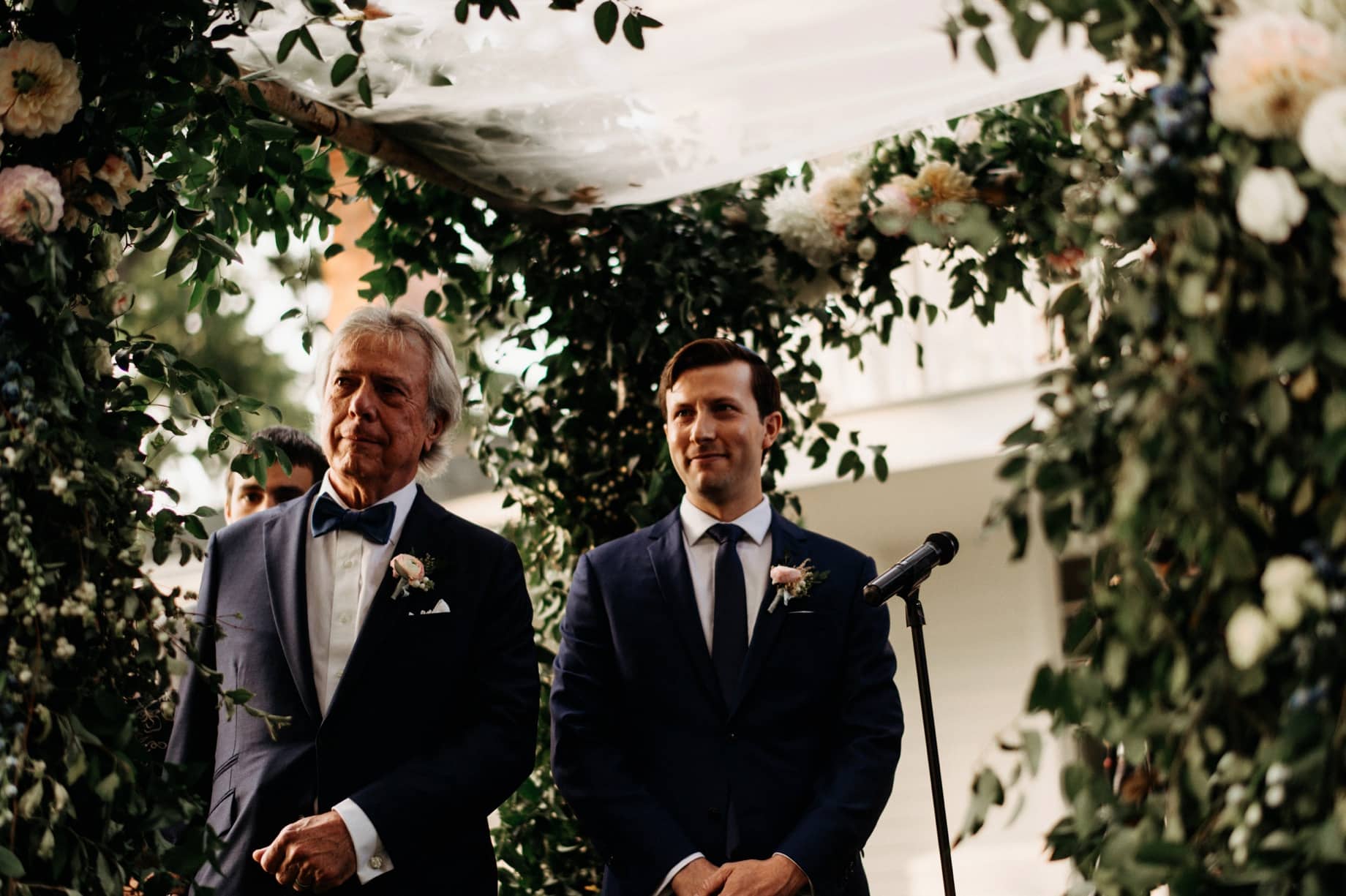 groom watching his bride walk down the aisle