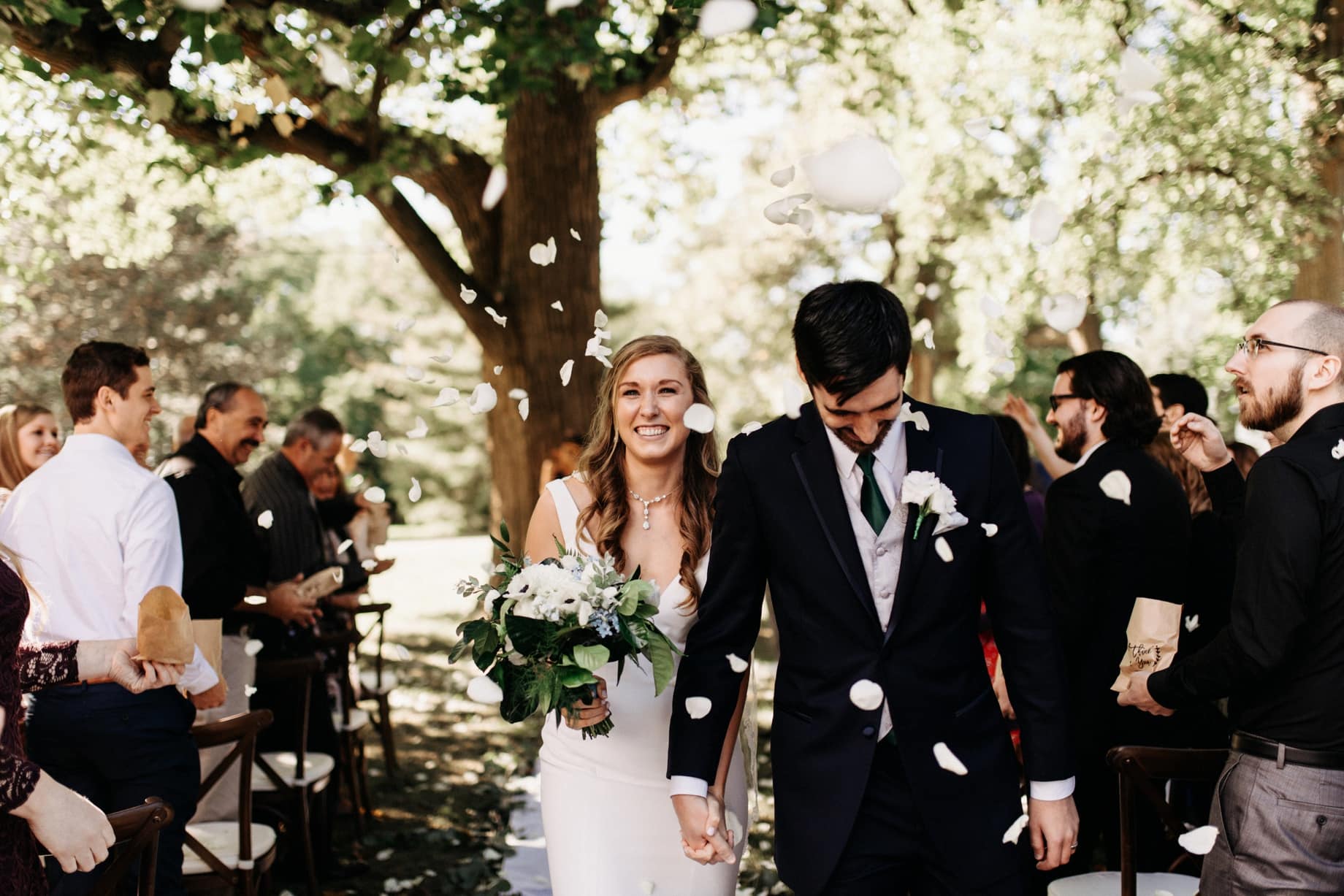 wedding guest throw petals on a couple after their wedding ceremony