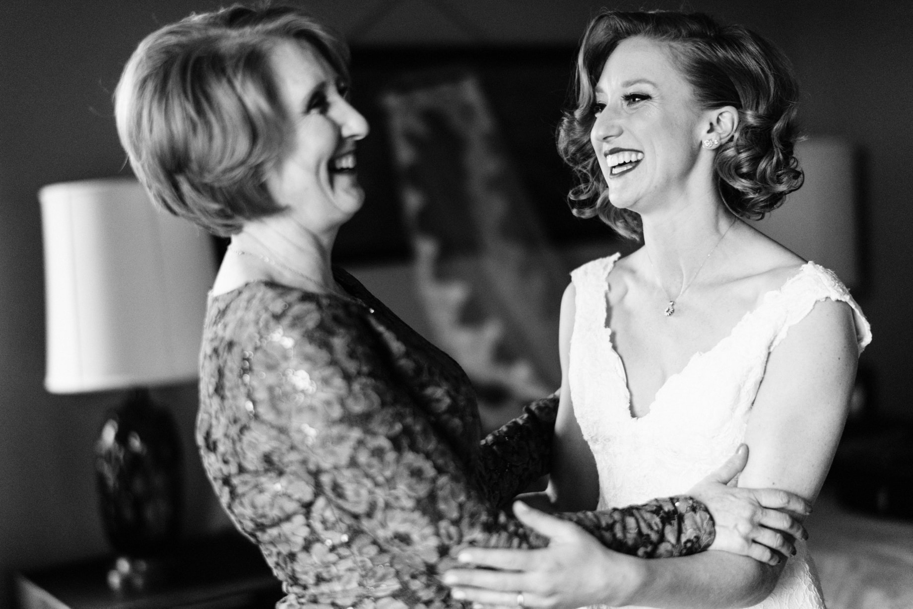 bride and her mother share a moment after bride puts on her wedding dress by Detroit wedding photograher Heather Jowett