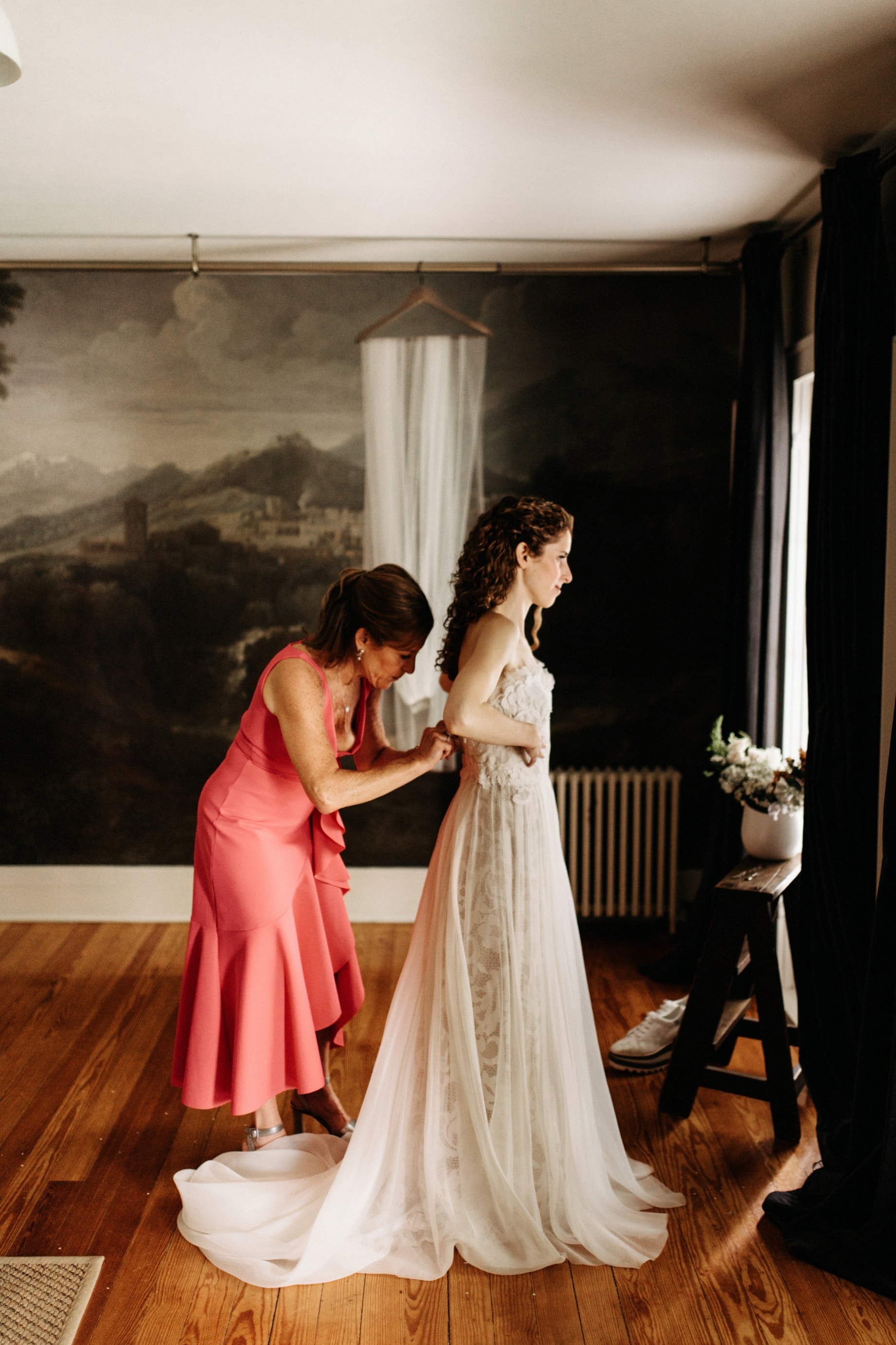 mother helps daughter into her dress at a cornman farms wedding
