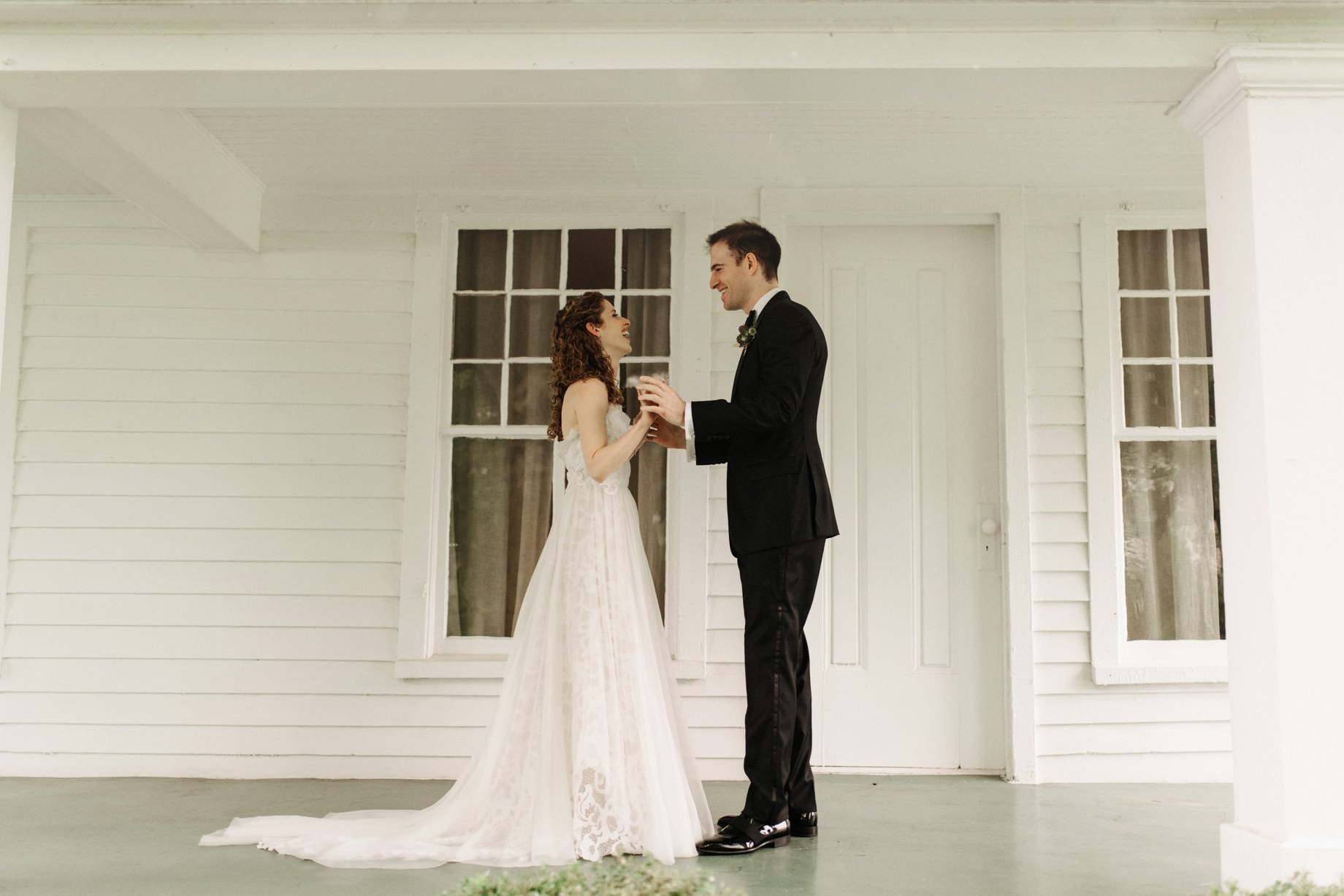 bride and groom share a first look on the front porch of cornman farms