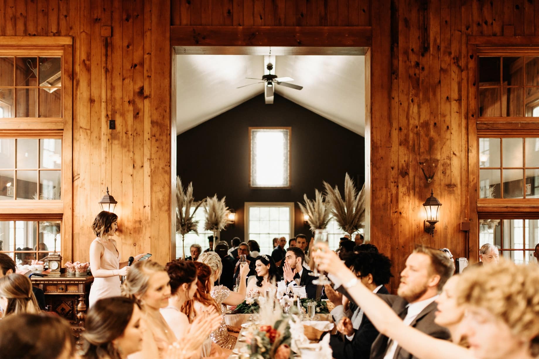 guests raise a glass during toasts at a wellers carriage house wedding