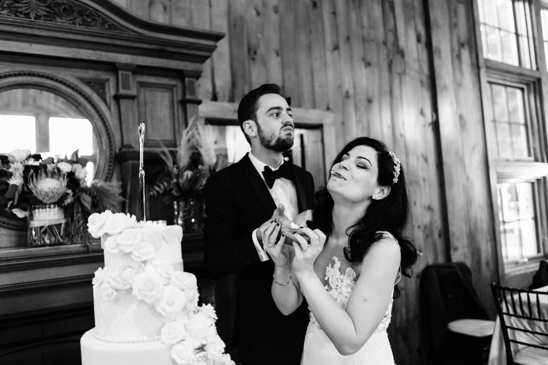 bride and groom taking a first bite of their wedding cake