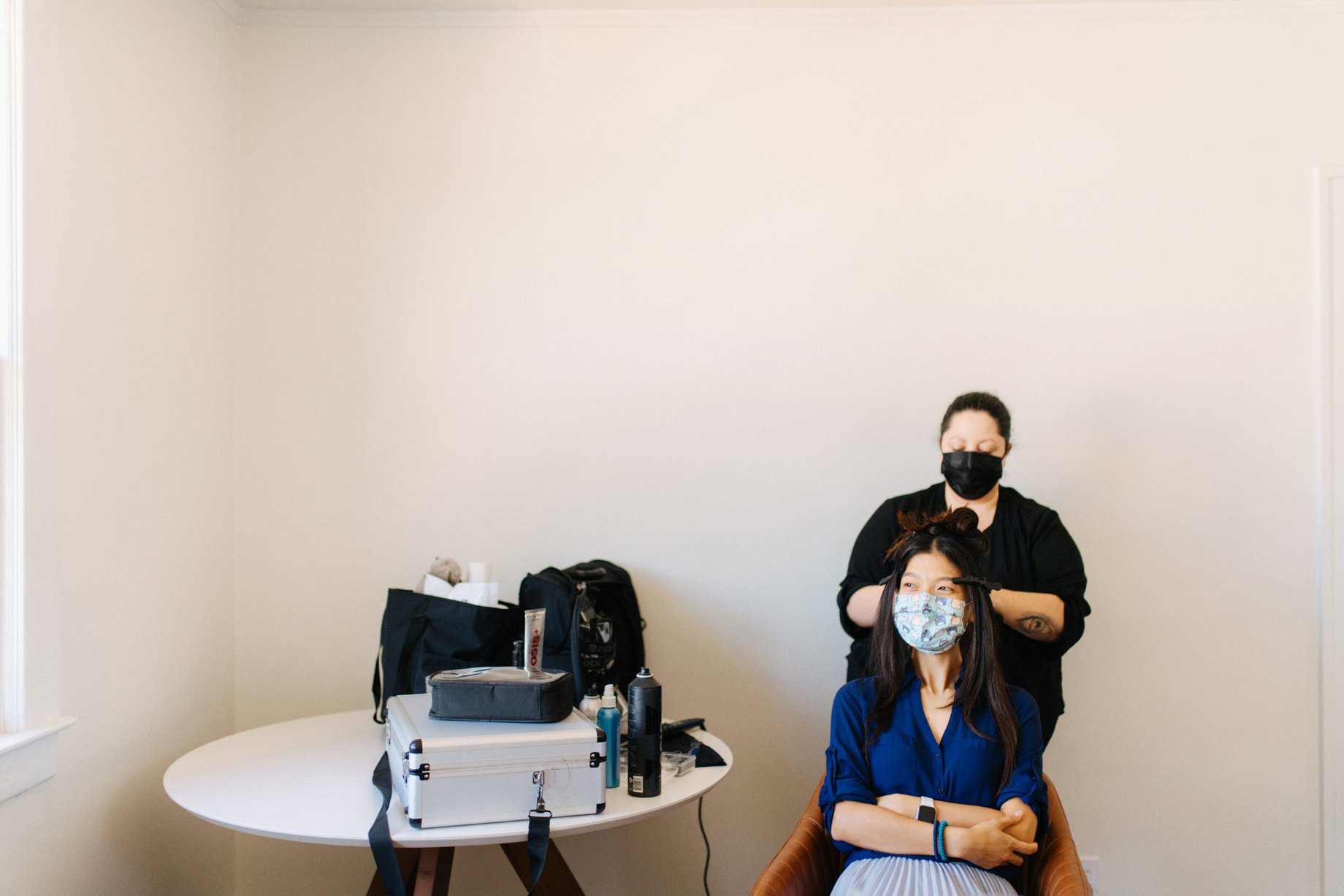 a bride gets ready while wearing a face mask by photojournalistic Detroit wedding photographer Heather Jowett