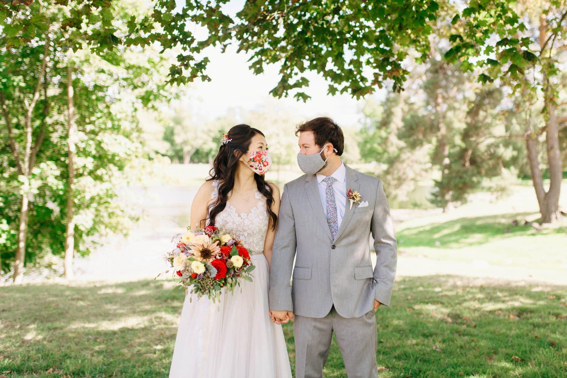 A couple posing in masks on their wedding day during covid 19