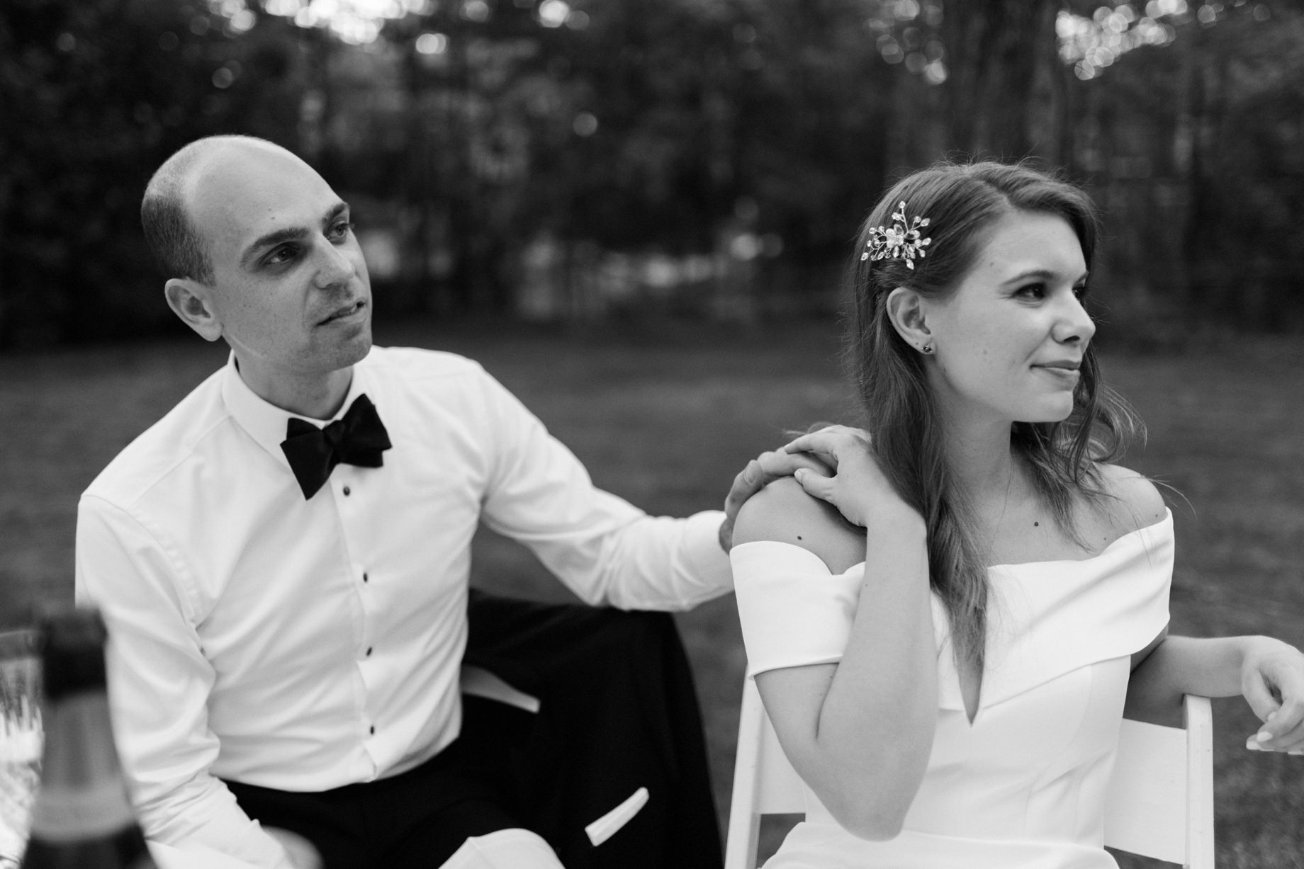 groom reaches out and places a hand on his brides shoulder during toasts