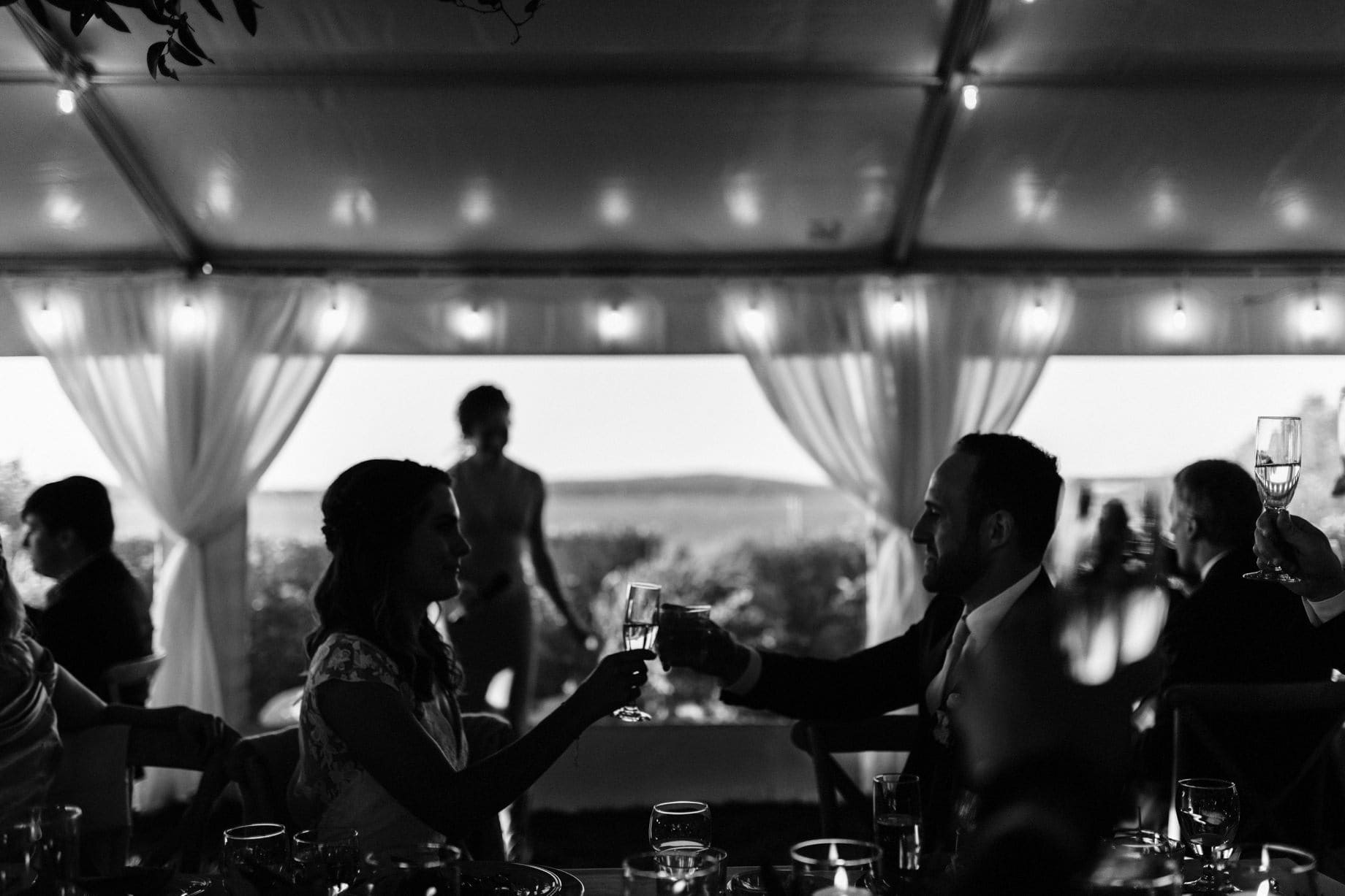 black and white photograph of a couple toasting on their wedding day