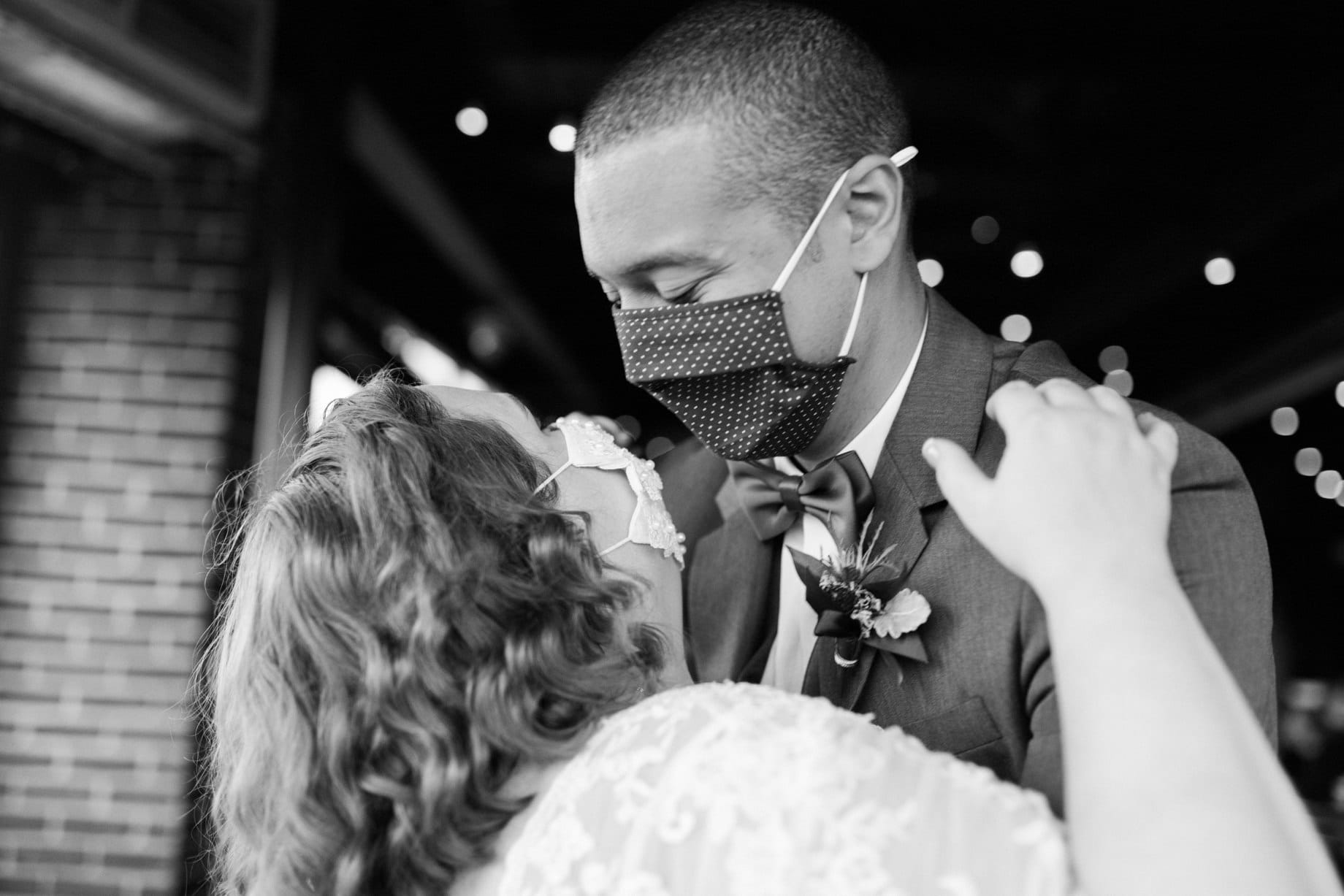 bride and groom dance with masks on during their covid wedding