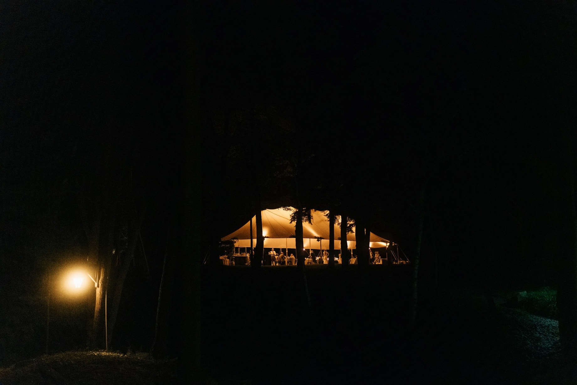 a night shot of a wedding reception tent in the woods