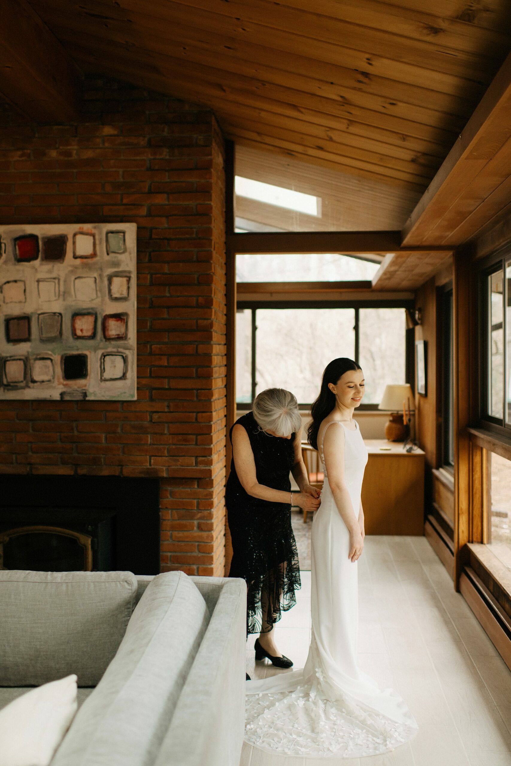 mother helping bride into dress 1