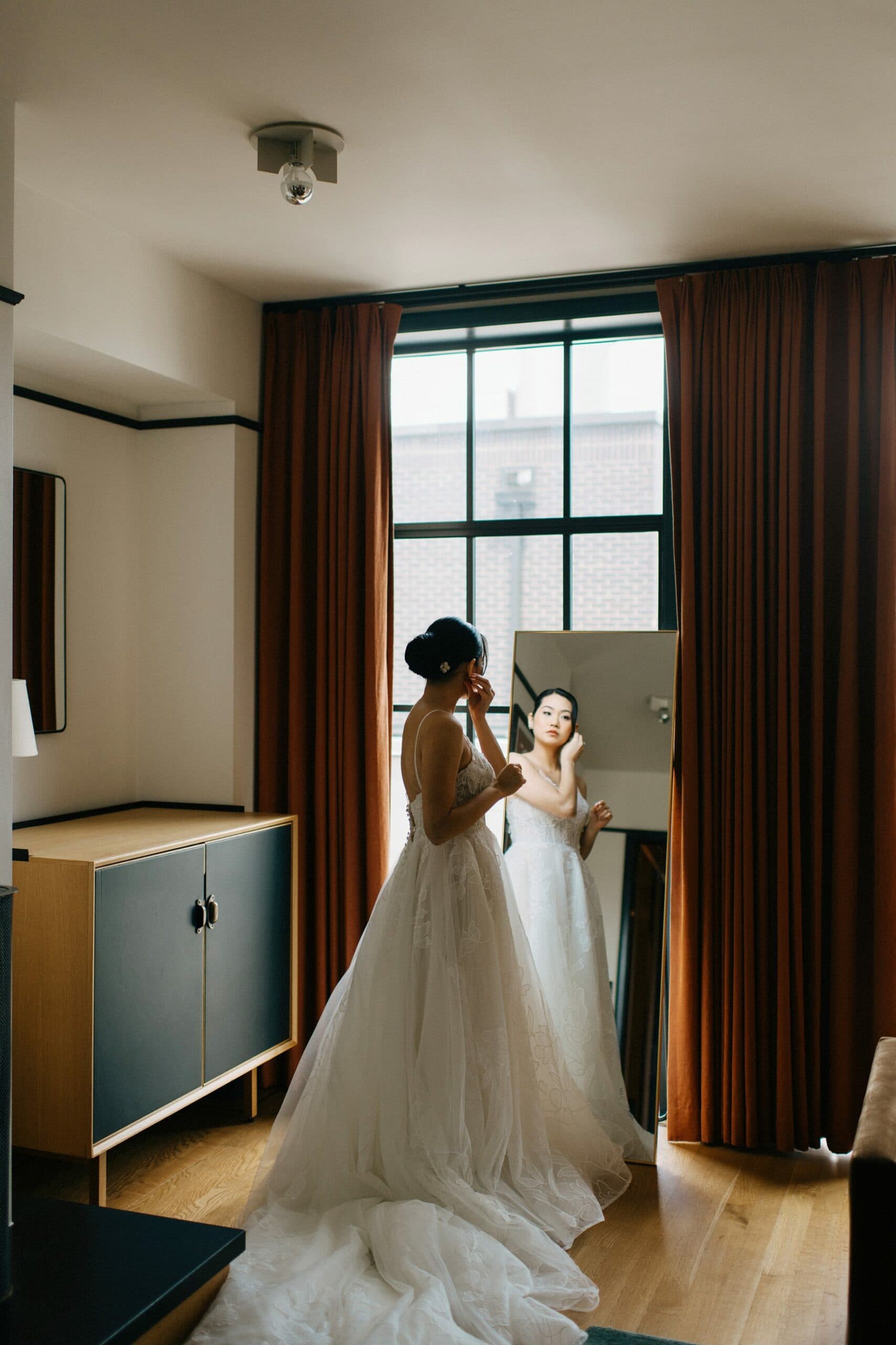 a photograph of a bride getting dressed in her suite at the Shinola Hotel by Detroit Wedding Photographer Heather Jowett