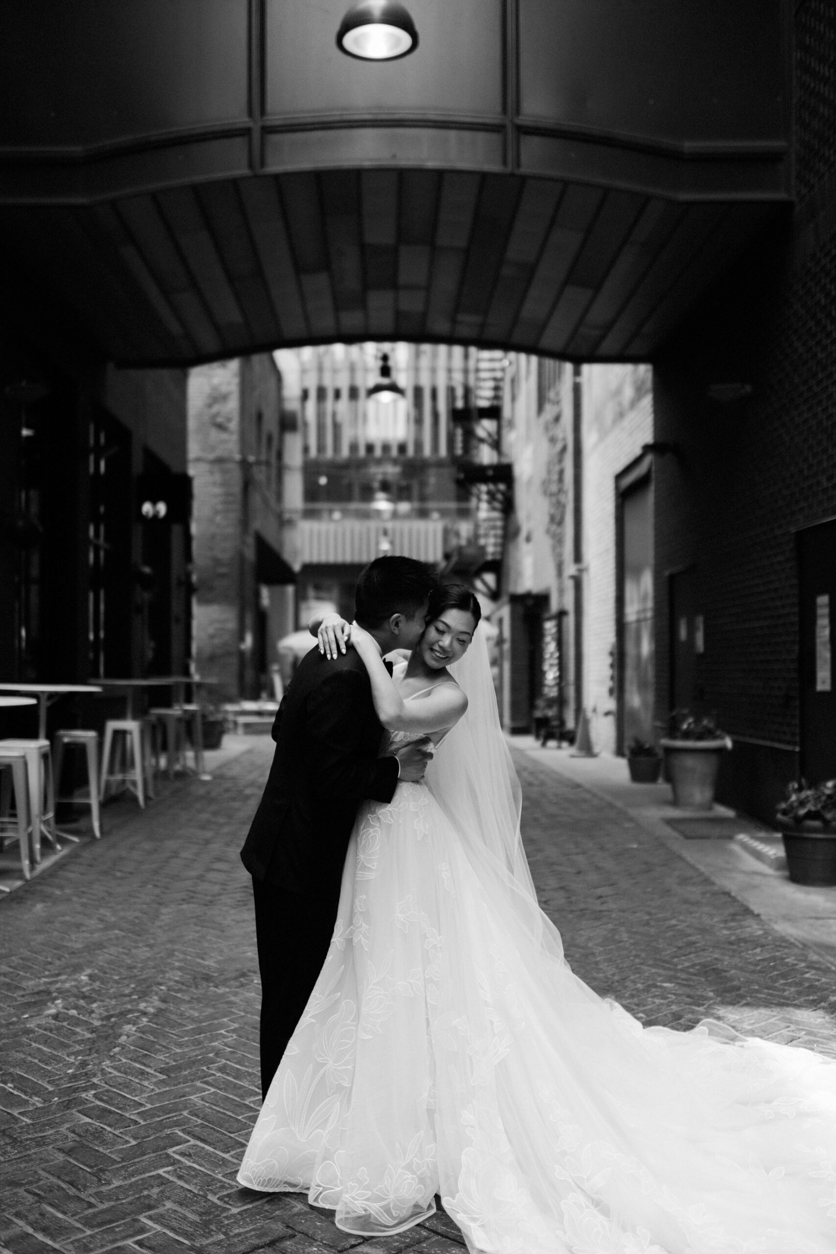 The couple shares a joyful embrace in parkers alley captured in classic black and white documentary style