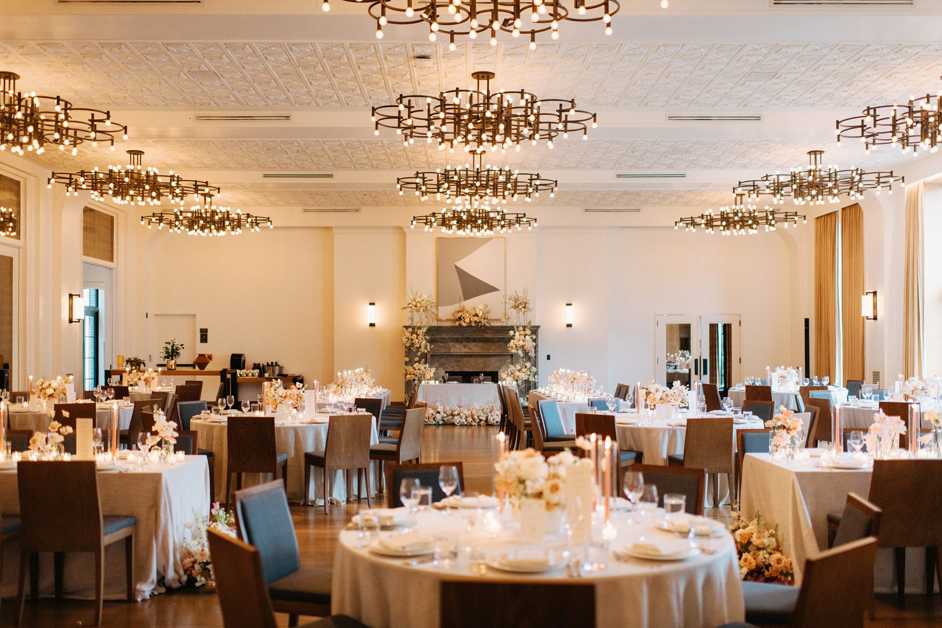 The reception space at the Shinola Hotel features soft lighting from modern chandeliers