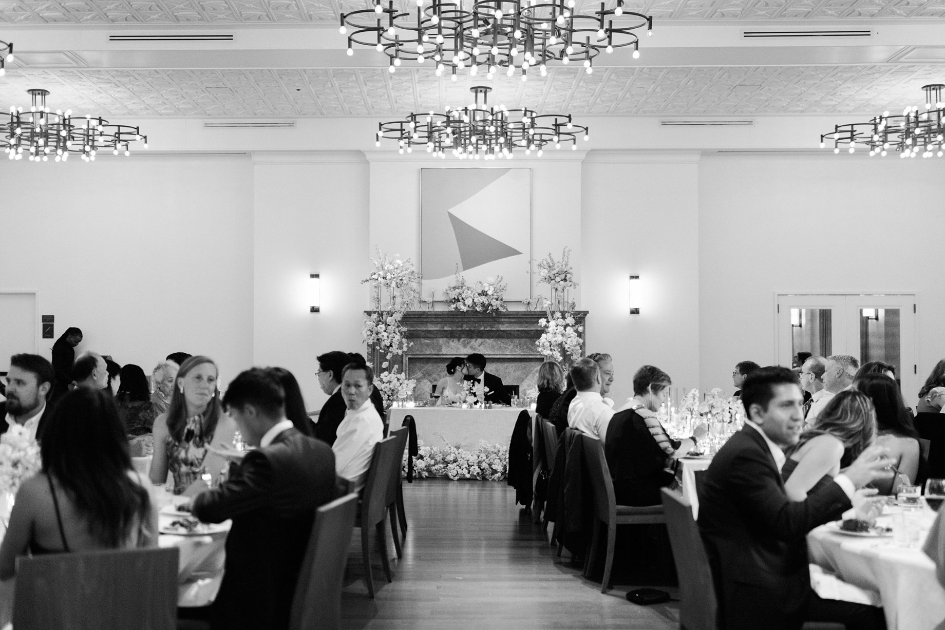 couple seated at the head table surrounded by guests during dinner