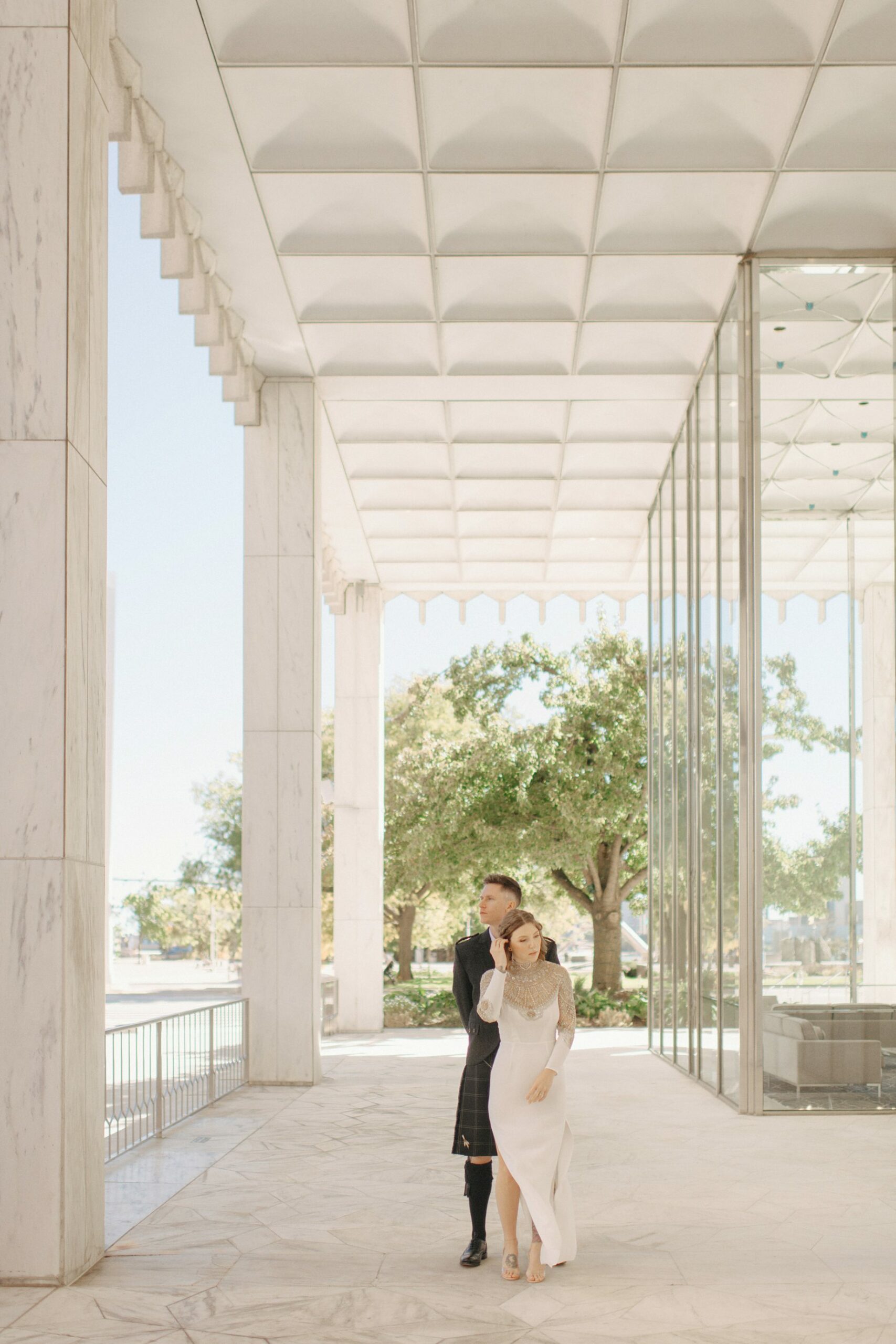 Bride and groom share a quiet moment outside of One Woodward in downtown Detroit in elegant editorial wedding photography in the city