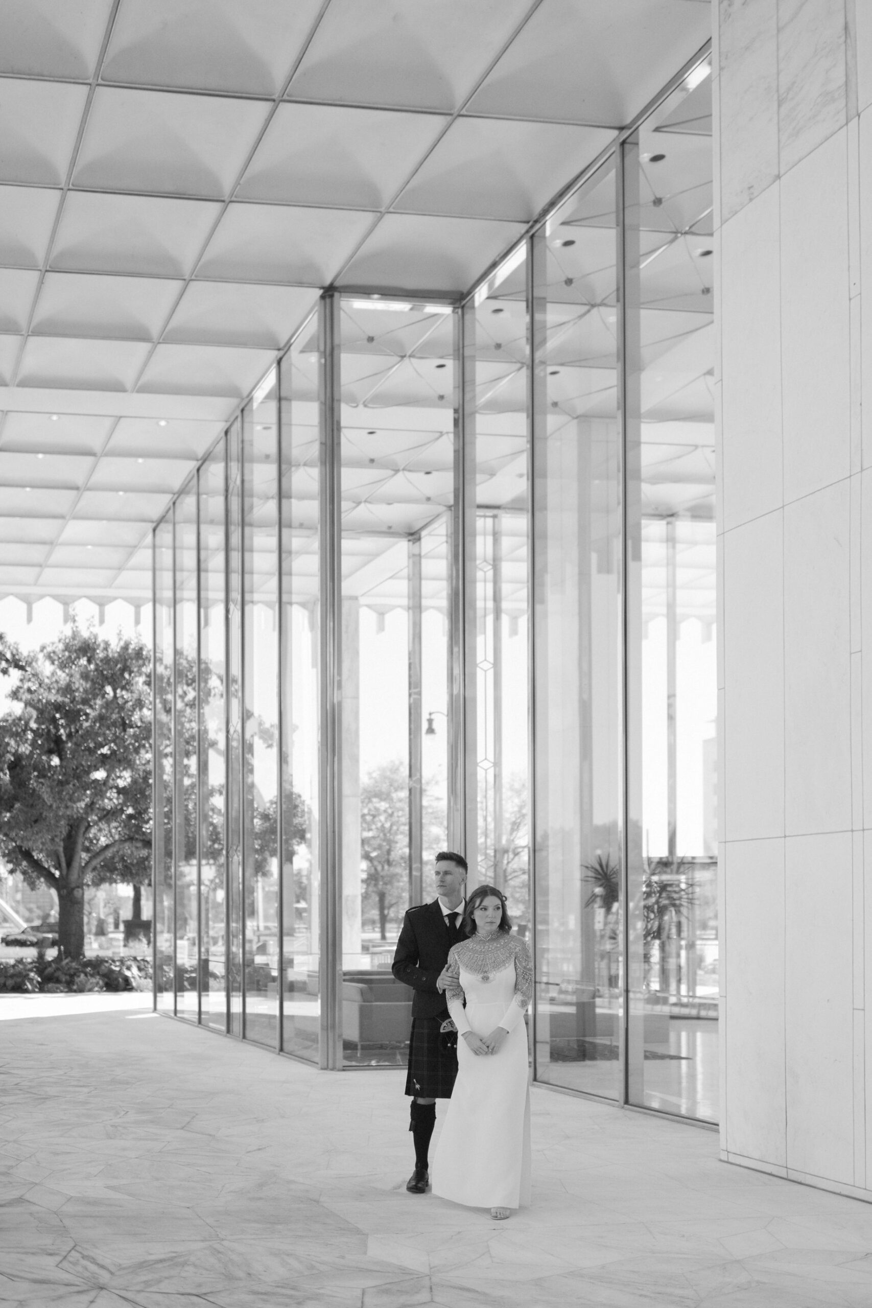 Bride and groom share a quiet moment outside of One Woodward in downtown Detroit in elegant editorial wedding photography in the city