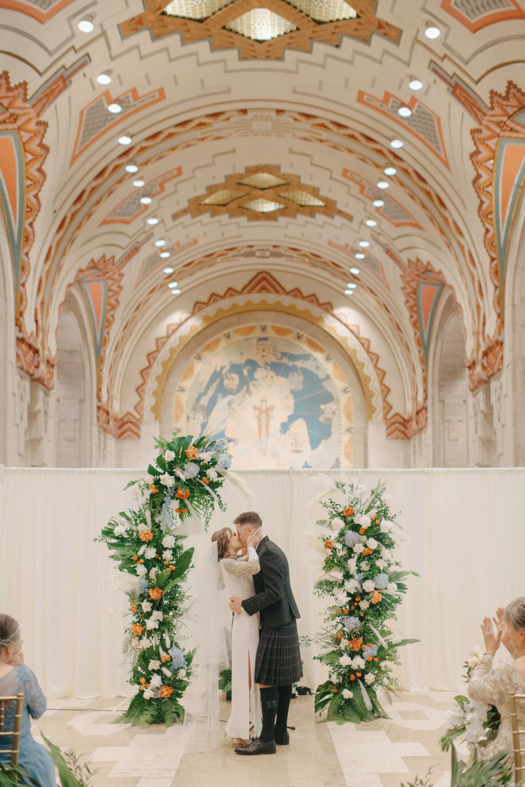 bride and groom exchanging their first kiss during their wedding ceremony in the guardian building in downtown detroit