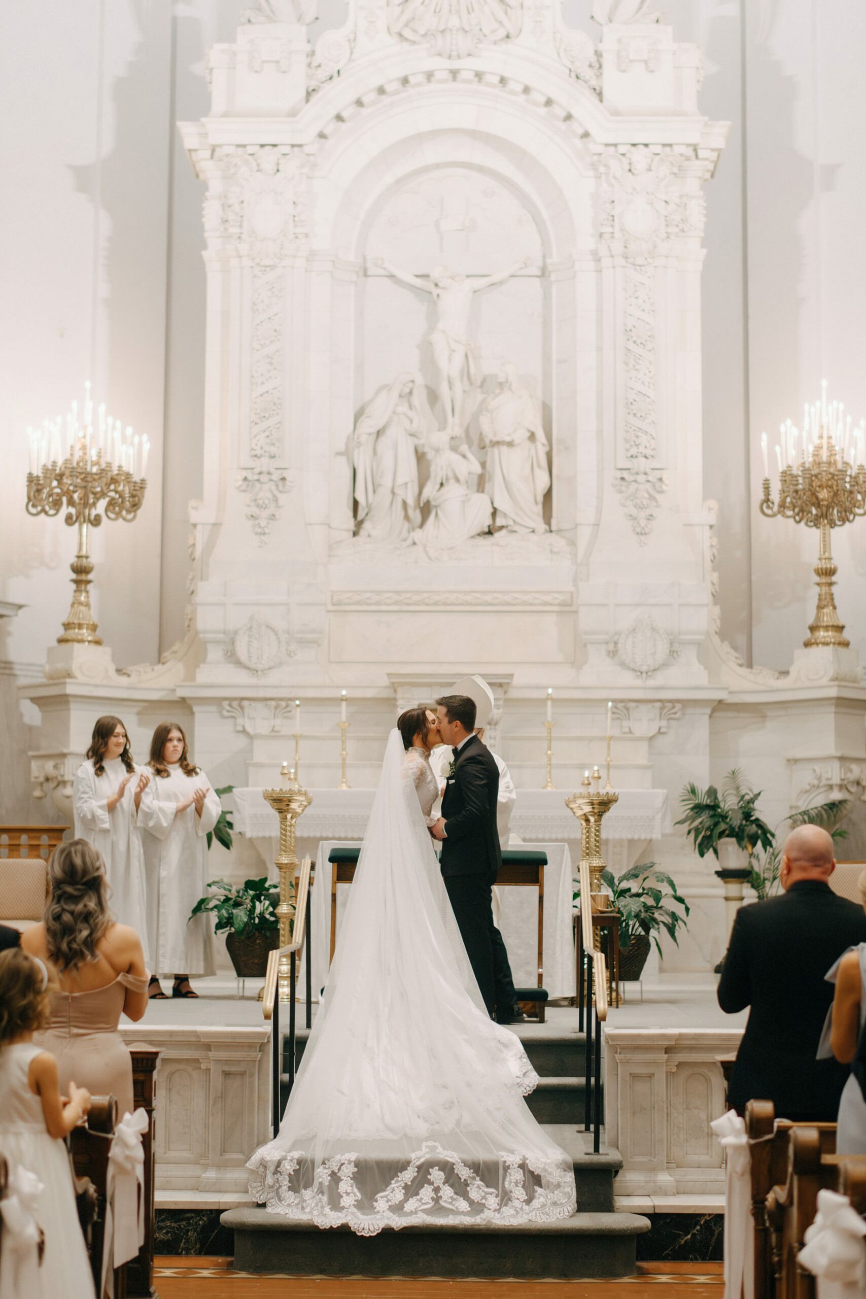 Bride and groom share their first kiss during a Catholic wedding ceremony at Saints Peter and Paul Jesuit Church in Detroit