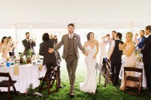 bride and groom entering tented reception