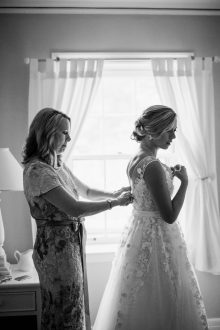 mother helps daughter into wedding dress