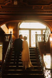 bride and groom pose for portrait on the stairs at the Whitney