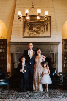 bride and groom pose with their children on their wedding day