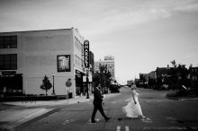 bride and groom crossing the street in pontiac by Michigan wedding photographer heather jowett