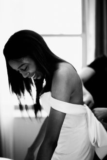 black and white photo of bride getting dress by Detroit wedding photographer Heather Jowett