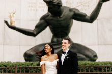 bride and groom laughing in front of spirit of detroit
