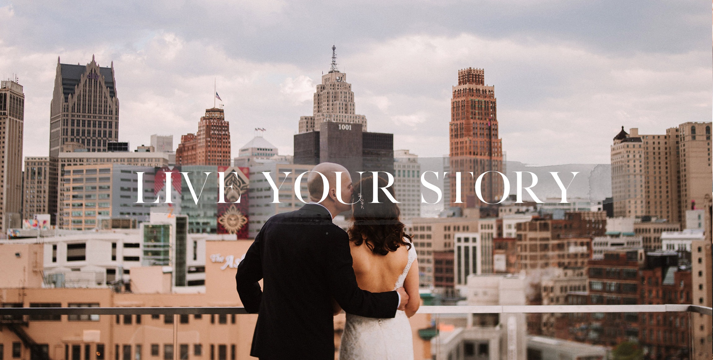 a couple in front of the detroit skyline
