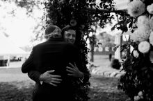 groom hugs father at the beginning of his jewish wedding ceremony at cornman farms
